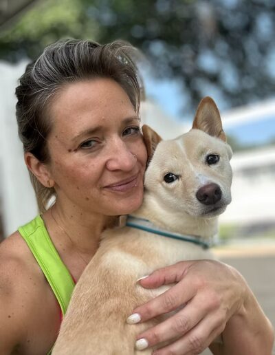Staff member holding small white dog